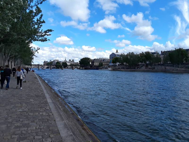 Approaching Pont des Arts or Passerelle des Arts across the Seine River through Paris.