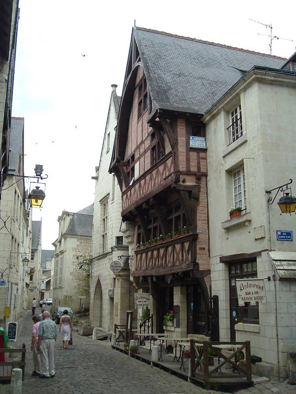 A half-timbered house along a narrow street in Chinon, with rue Jeanne d'Arc leading off to the right.