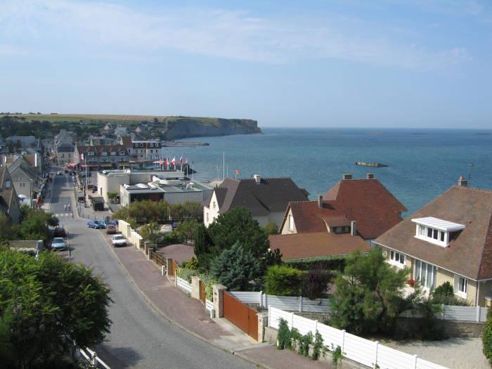 The harbor at Arromanches.  Mulberry artificial harbors from D-Day are visible in the bay.  Cliffs in the distance