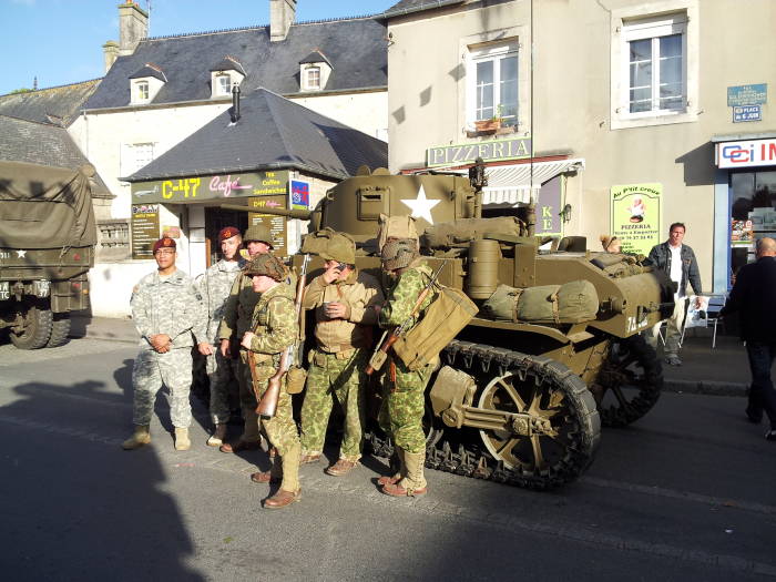 Actual U.S. forces join French and Belgian reenactors as U.S. forces and French Underground at Sainte-Mère-Église.