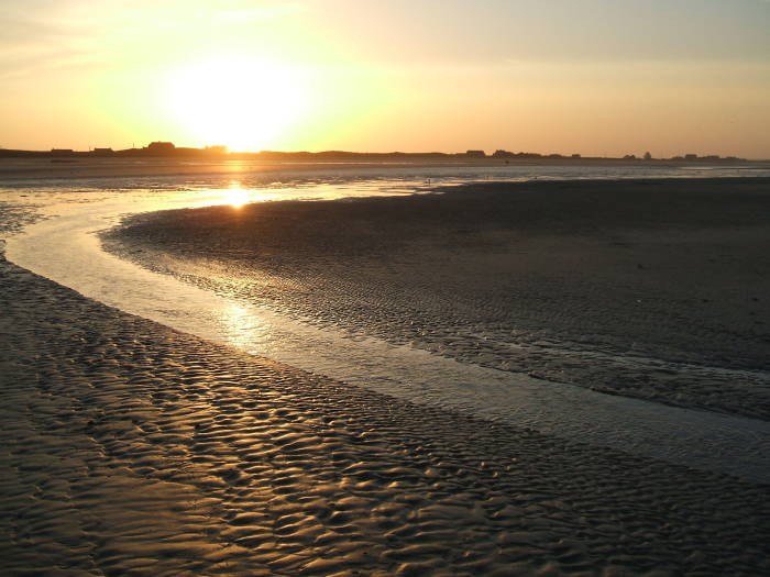 Sunset over Utah Beach.  A small beach village in the distance.
