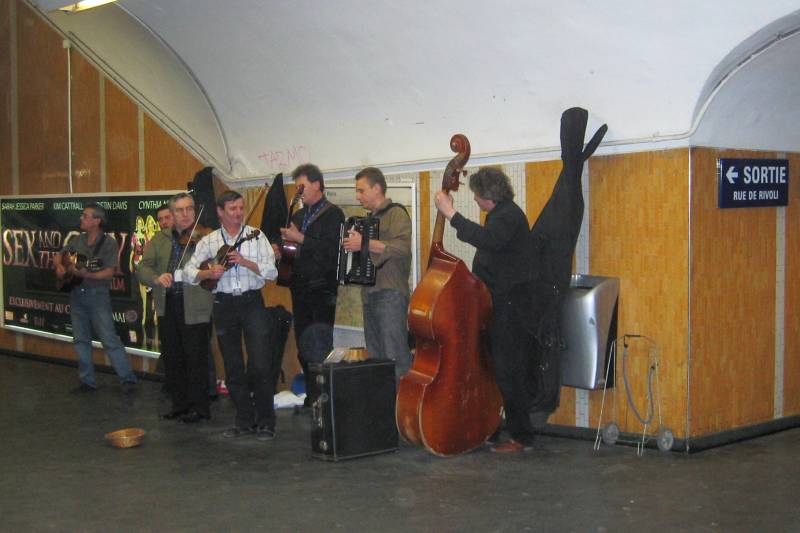 Group of musicians in Paris Métro station tunnel.