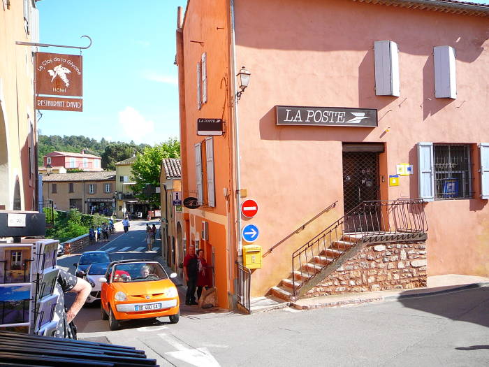 The D105 road runs through Roussillon, past La Poste.