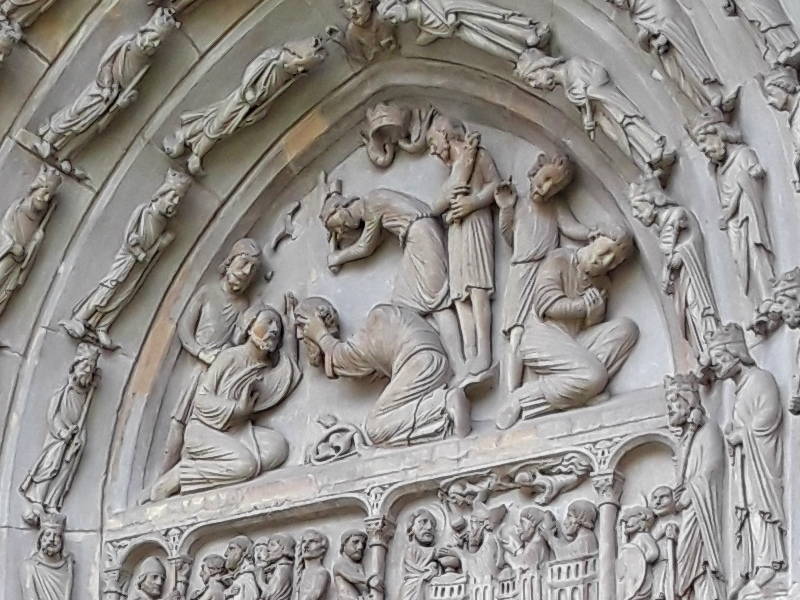 Saint Denis being martyred, on the side entrance to Basilique Saint-Denis, west arm of the crossing.