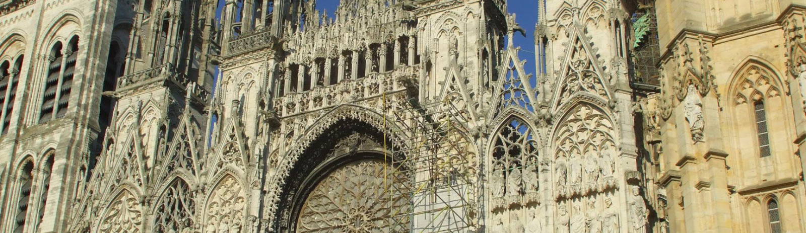 Façade of Cathédrale Notre-Dame de l'Assomption in Rouen, France on a sunny afternoon.