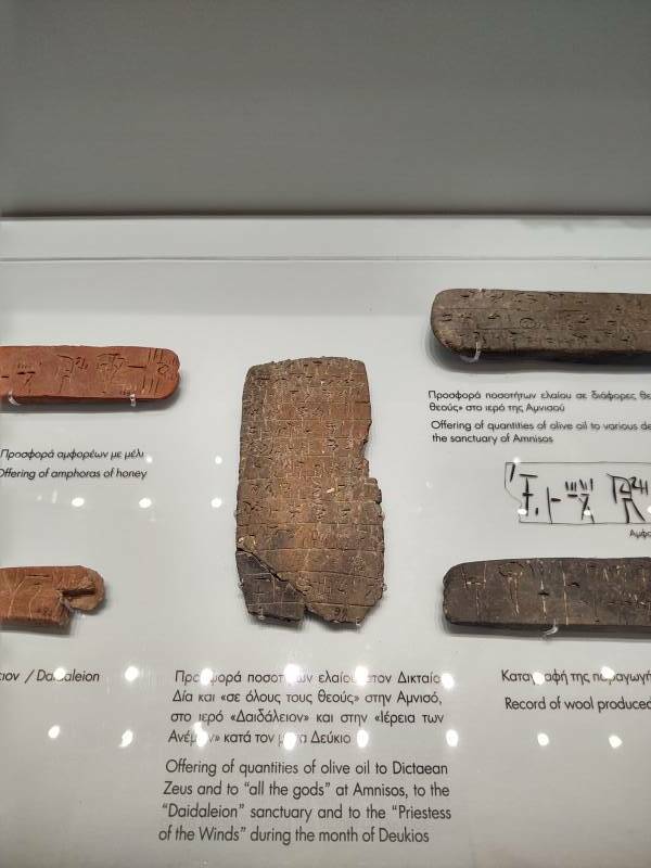 Clay tablets with Linear B script recording a mixture of religious and business details.