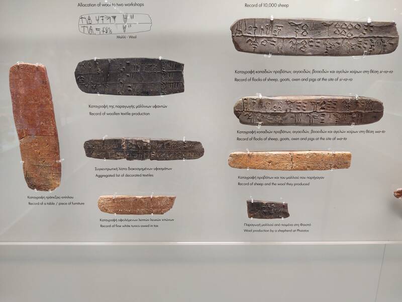 Clay tablets with Linear B script recording agricultural and trade details.