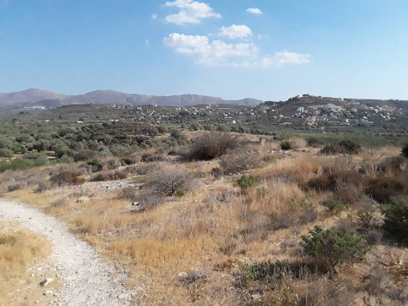 Kamilari hilltop village in the distance, seen while approaching the Kamilari tholos tomb cluster.