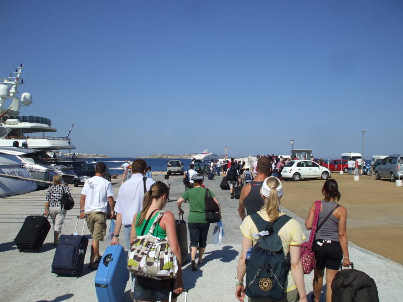 Passengers walk to the pier as a SeaJets ferry approaches Mykonos.