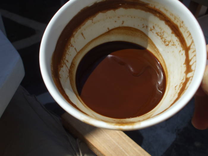 Cup of Greek coffee with grounds, at a waterfront cafe on the Greek island of Mykonos.