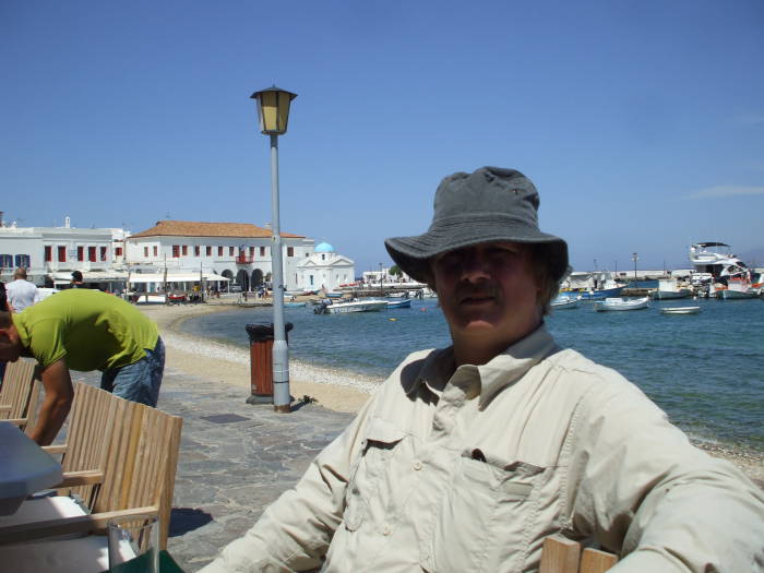 Bob Cromwell sitting at a waterfront cafe on the Greek island of Mykonos.