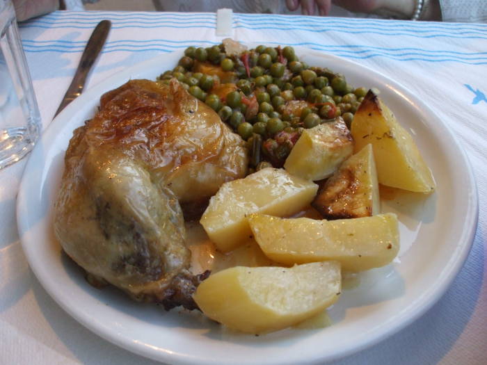 Dinner at a taverna in Thessaloniki: roasted chicken, green peas, and potatos.