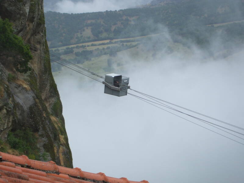 Greek Orthodox priest travels by small cable car to the monastery Moni Megalou Meteorou in Meteora.