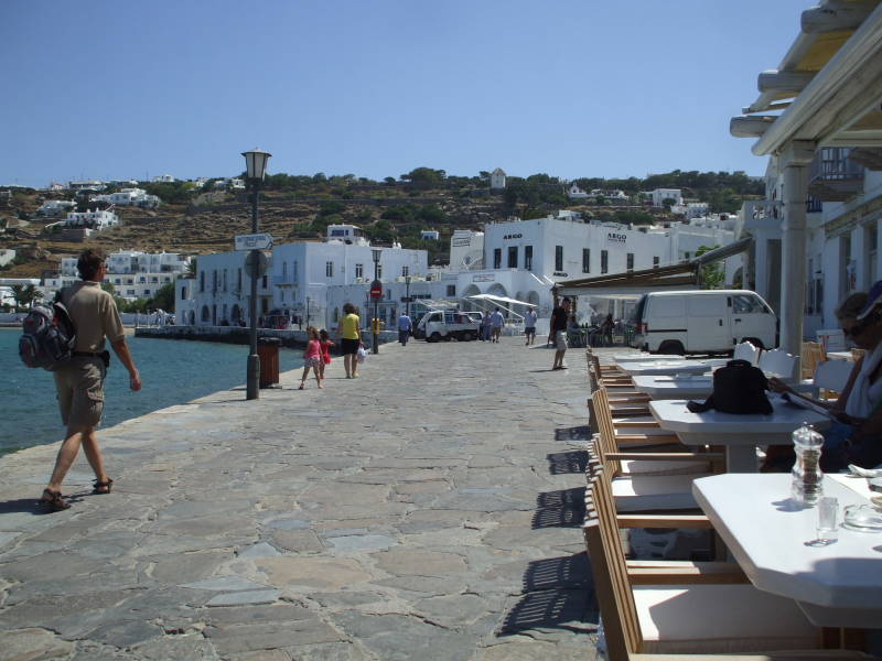 Tables at cafes along the harbor on Mykonos.