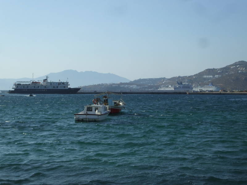 The ferry port and cruise ship port on Mykonos, with a small ferry and two large cruise ships.