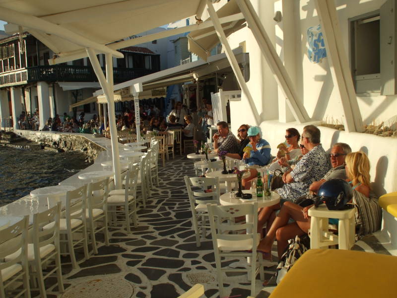 People gather for sunset at waterfront cafes in Little Venice in Hora, on Mykonos.