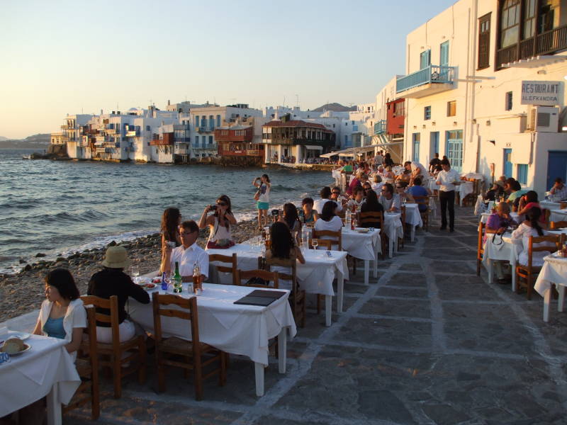 People gather for sunset at waterfront cafes in Little Venice in Hora, on Mykonos.