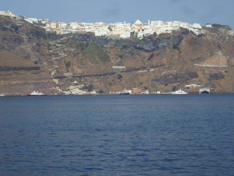 Fira, the main town on Santorini, with its donkey path and cable car, seen from the ferry in the caldera.