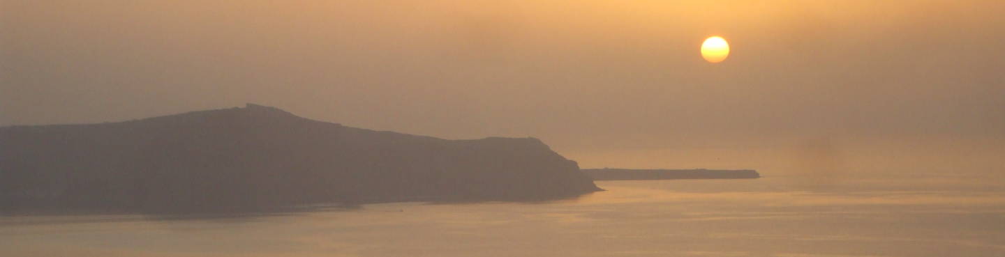 The sun sets over the Santorini caldera.