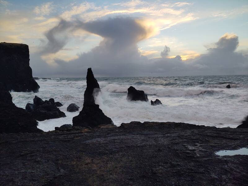 Large waves crashing into the Reykjanestá point beyond Reykjanes Lighthouse.