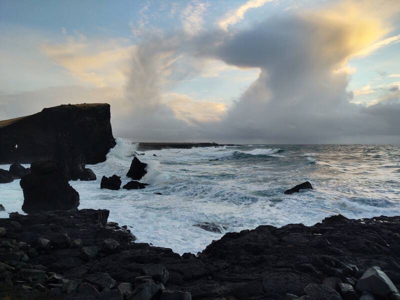 Large waves crashing into the Reykjanestá point beyond Reykjanes Lighthouse.