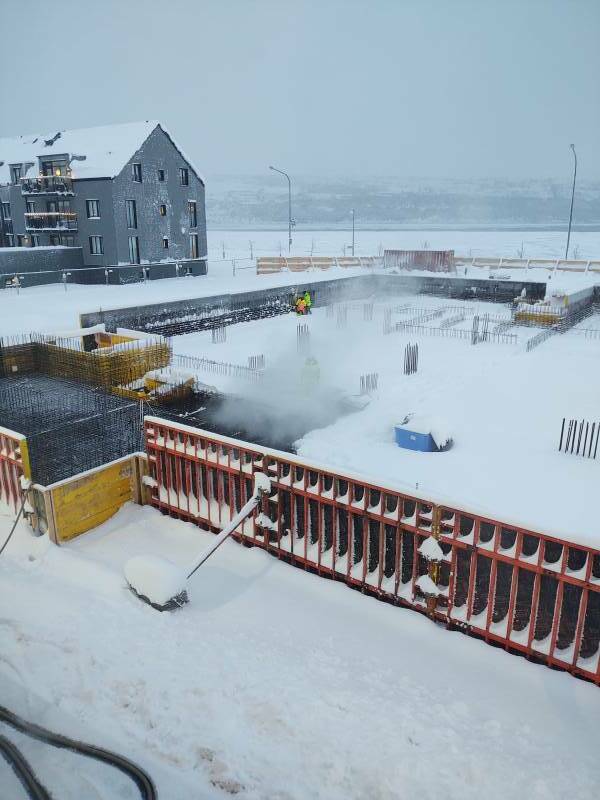 Construction workers removing snow with steam in Akureyri.