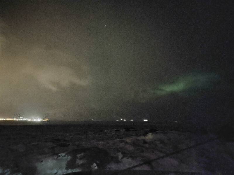 Aurora dimly seen through clouds from outside Sauðárkrókur.