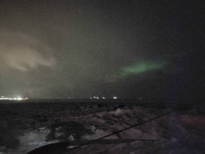 Aurora dimly seen through clouds from outside Sauðárkrókur.