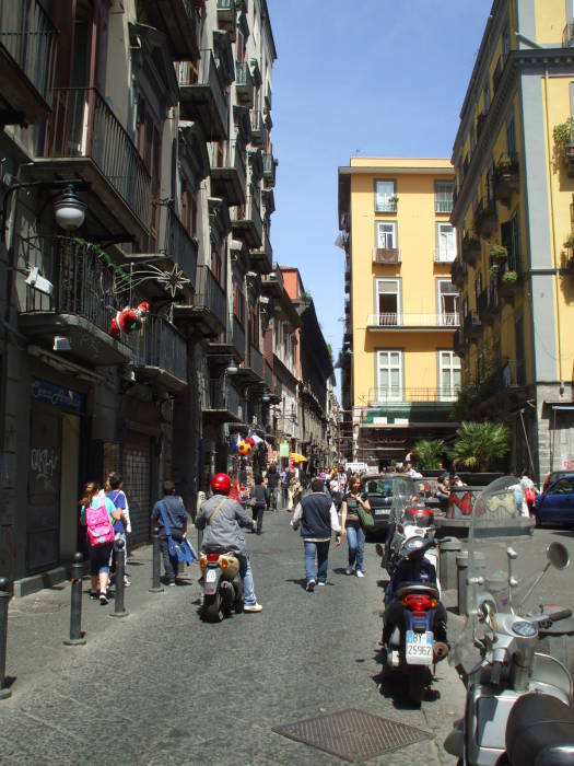 A busy street in Naple's Centro Storico: motor scooters, people on errands.