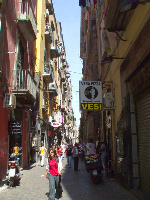 A narrow street with an authentic Neapolitan pizza shop.