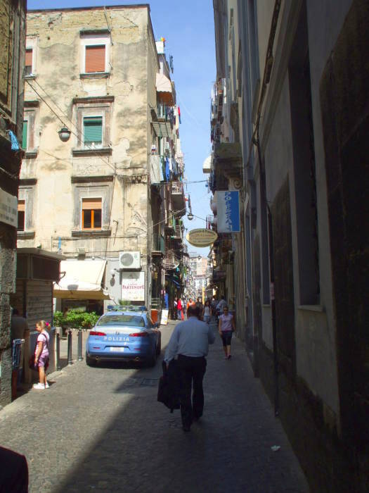 A narrow street with a small car in Naple's Centro Storico.