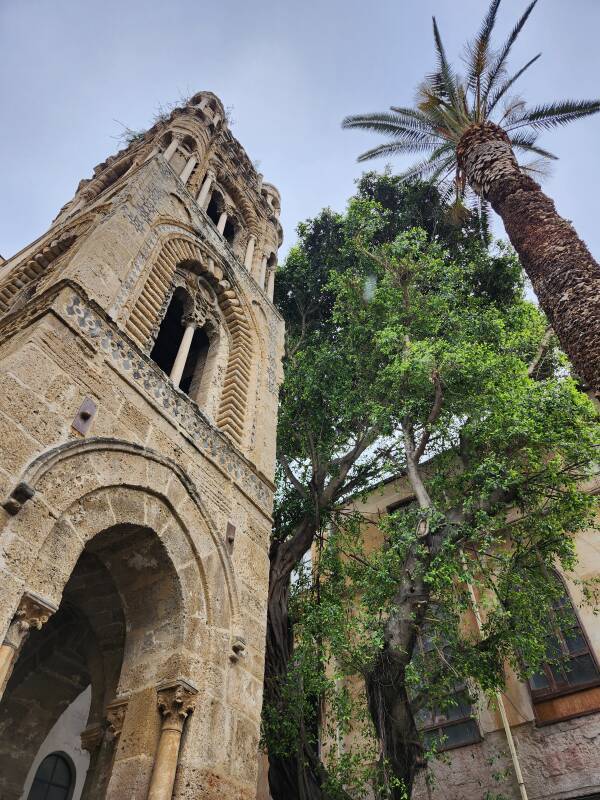 Bell tower and tall palm tree at the entrance.