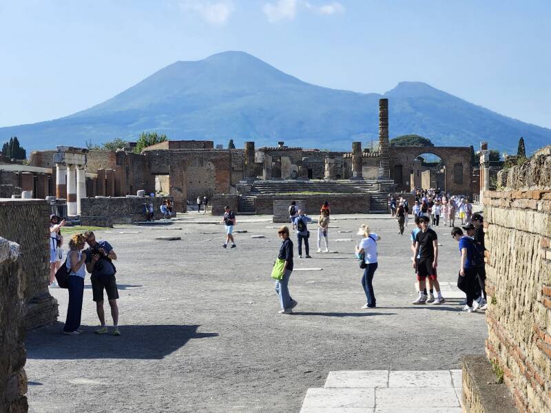 Visitors in the Forum with Vesuvius beyond.