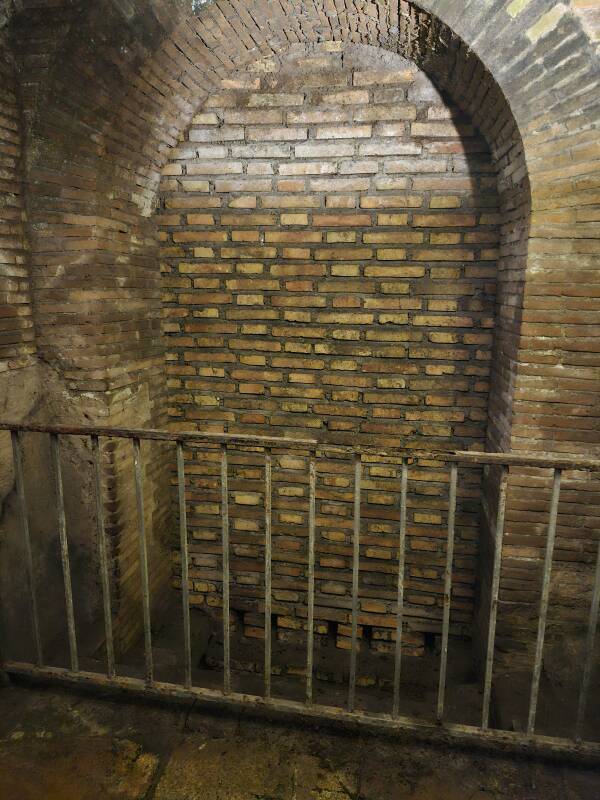 Drain within a brick arch with a modern railing added.