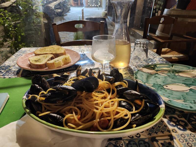 Spaghetti with mussels and a carafe of white wine.