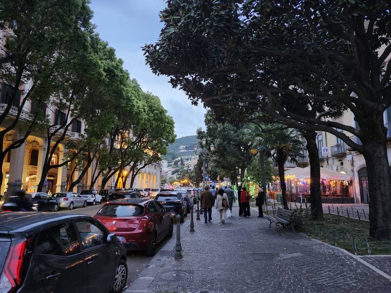 Brightly lit restaurants along the waterfront avenue in Salerno.