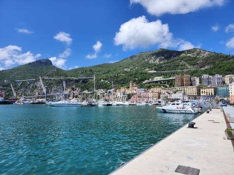 harbor and waterfront of Salerno, tall arched highway bridges, steep mountains.