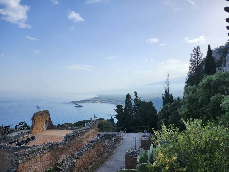 Greek theatre in Taormina with the sea and Mount Etna in the background.