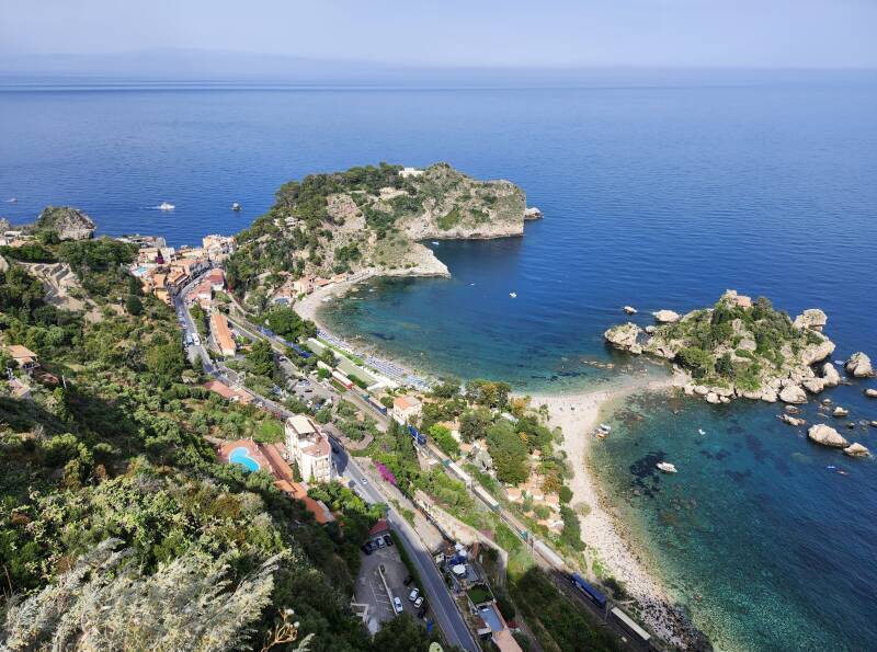 Freight train running along the shore below Taormina.
