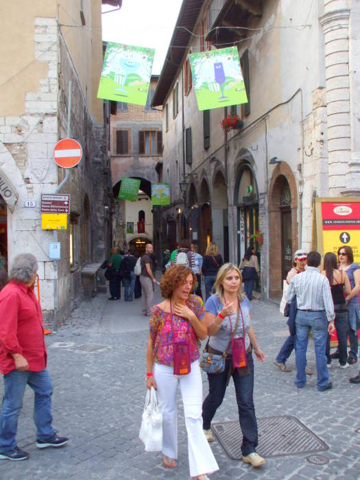 Two girls carrying wine glasses at the Spoleto wine festival.
