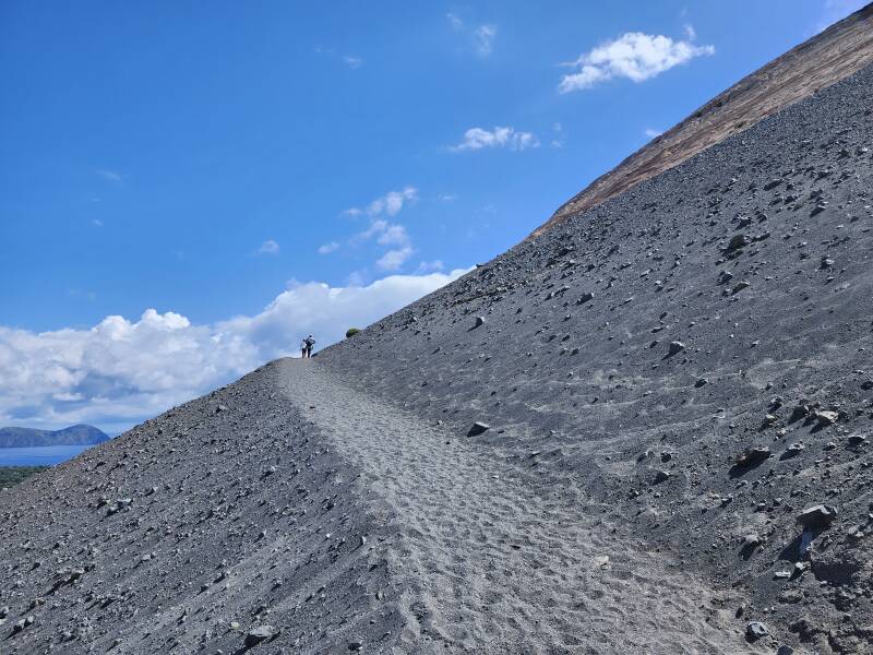 The path continues upward through coarse sand.