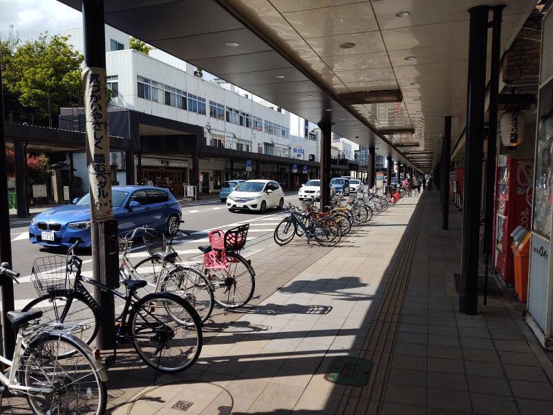 Many bicycles parked along a covered sidewalk in Aizu-Wakamatsu.