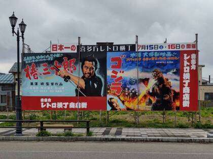 Billboard with large movie posters of Mifune Toshiro in Akira Kurosawa's 'Sanjuro' and Gojira or Godzilla in Kitakata.