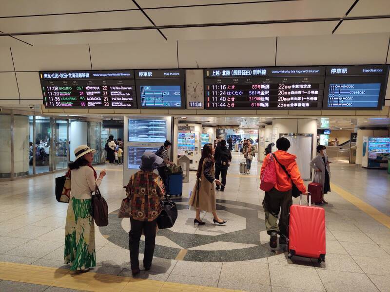 Overhead sign showing Shinkansen schedules and tracks Tōkyō Station.