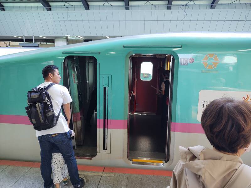 Man showing his son the engineer's compartment of a Shinkansen at Tōkyō Station.