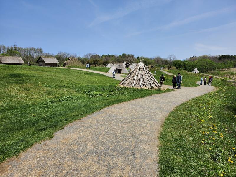 Reconstructed conical dwelling built from wood poles and bark pieces.