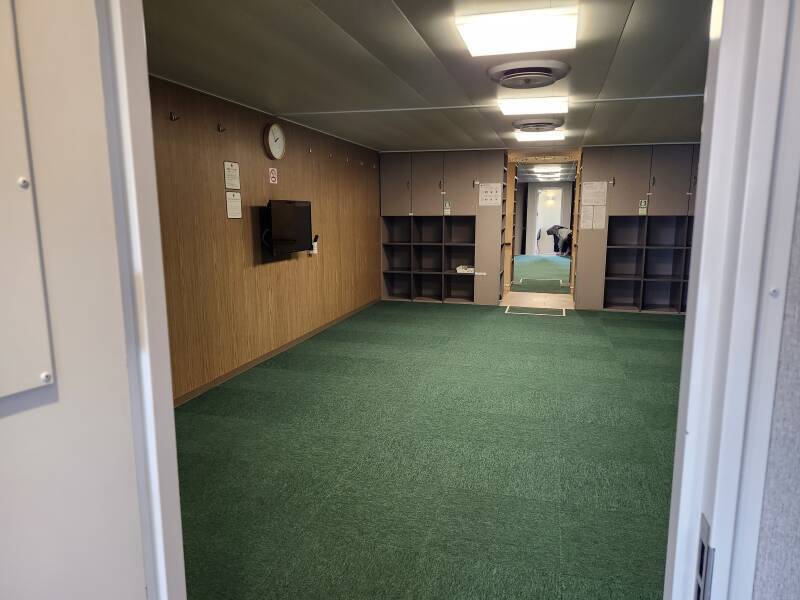 Green carpeted room occupied by many Standard passengers.