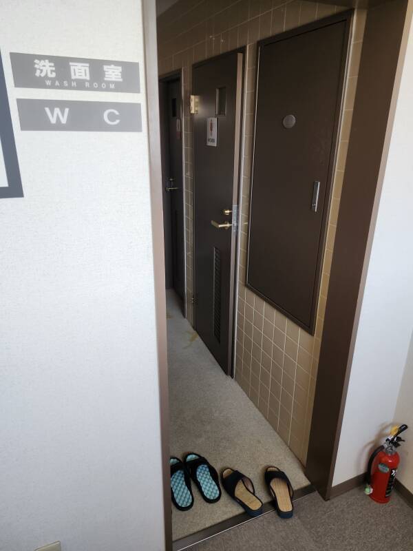 Shared bathroom with bathroom slippers.