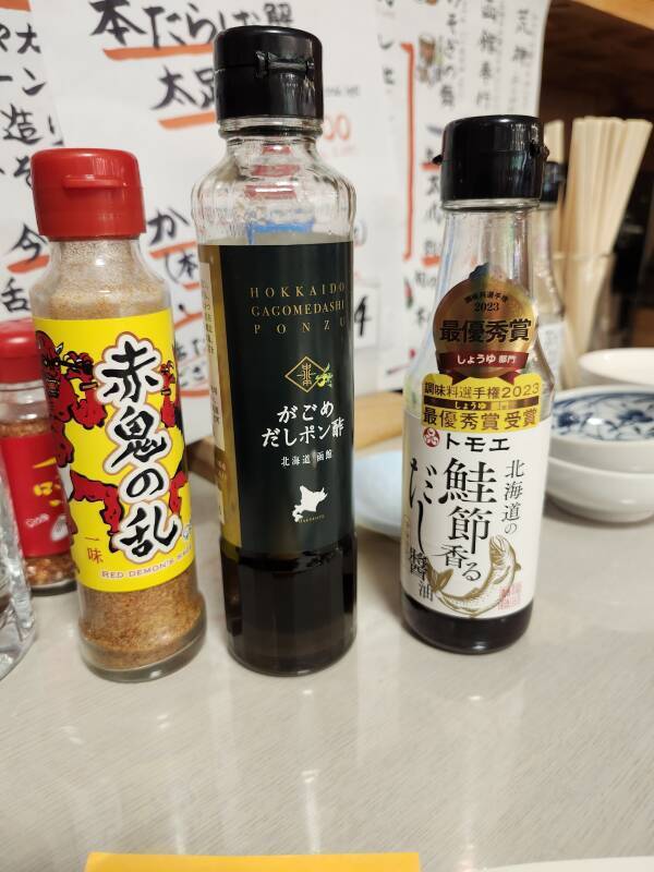 Left to right: ground red pepper, ponzu sauce, 'TO-MO-E'.