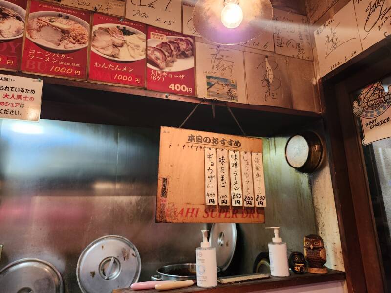 Cooking area and wall-mounted menu in a ramen restaurant in Daimon Yokocho.